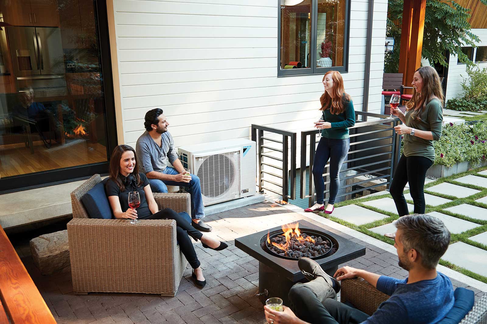 group of people sitting around fire pit with a daikin unit